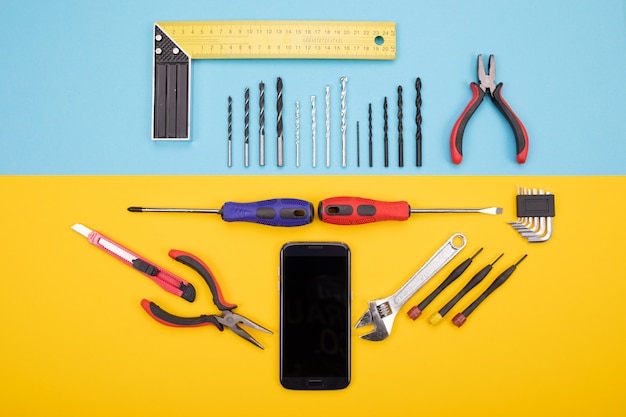 Foto conjunto de ferramentas para metais com smartphone em colorido