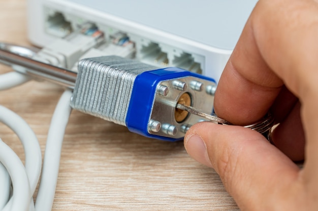 Conjunto de fios Ethernet de rede no roteador bloqueado com cadeado de metal