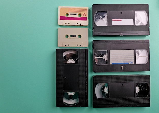 Foto conjunto de fitas antigas de áudio e vídeo em fundo turquesa