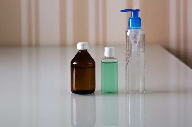 Conjunto de frascos com álcool e gel higiênico médico para higiene das mãos e proteção contra vírus corona. copie o espaço