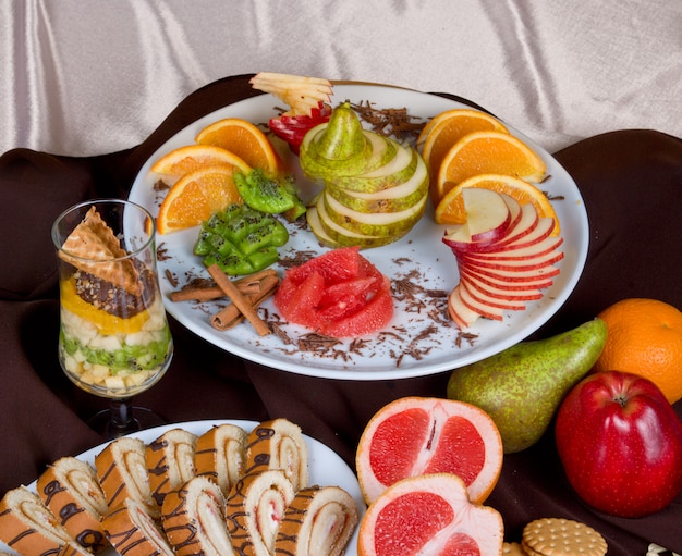 Conjunto de frutas doces e bolo em um fundo de mesa de restaurante