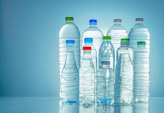 Conjunto de garrafa de água plástica transparente com rótulo em branco. Água limpa e garrafa mineral natural com tampa branca, verde, vermelha e azul. Bebida saudável. Coleção de garrafa de plástico.