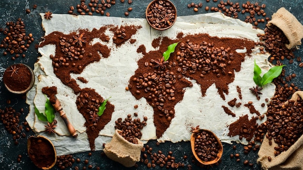 Conjunto de grãos de café e café moído em forma de mapa do mundo Vista superior Em um fundo escuro