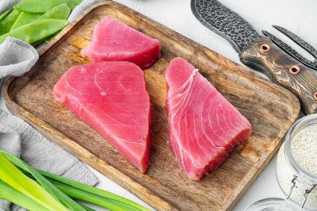 Conjunto de ingredientes de bife de atum com gergelim cru, em bandeja de madeira, sobre pedra branca