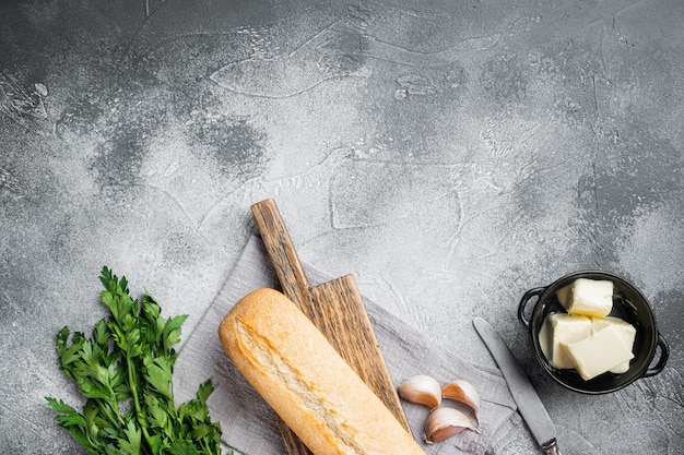 Conjunto de ingredientes de ervas e manteiga de pão de alho composto, no fundo da mesa de pedra cinza, vista de cima plana, com espaço de cópia para o texto