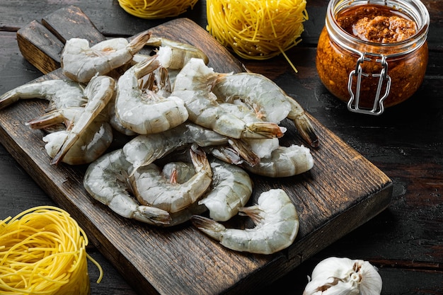 Conjunto de ingredientes de macarrão com pesto de rosa e camarão, em uma velha mesa de madeira escura