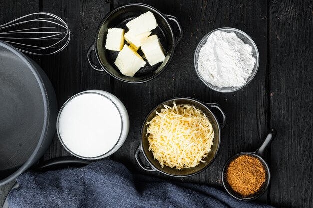 Conjunto de ingredientes do molho Bechamel Branco, em mesa de madeira preta