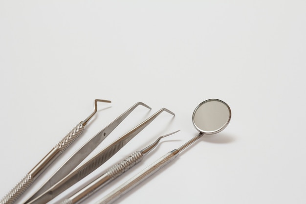 Conjunto de instrumentos de metal odontológico para tratamento dentário em fundo branco. Ferramentas médicas. Vista de perto. Profundidade superficial de campo.