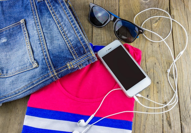 Conjunto de jeans de roupas da moda com uma camiseta e um smartphone