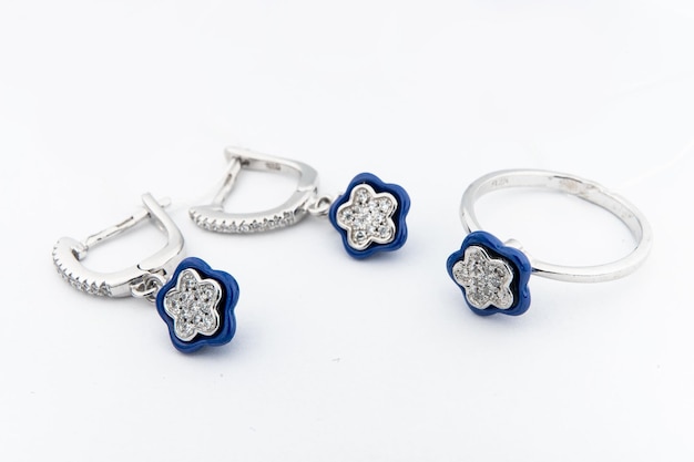 Conjunto de joias de prata de anel e brincos de prata com pedras em fundo branco Coleção de joias de prata