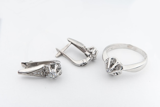 Conjunto de joias de prata de anel e brincos de prata com pedras em fundo branco Coleção de joias de prata