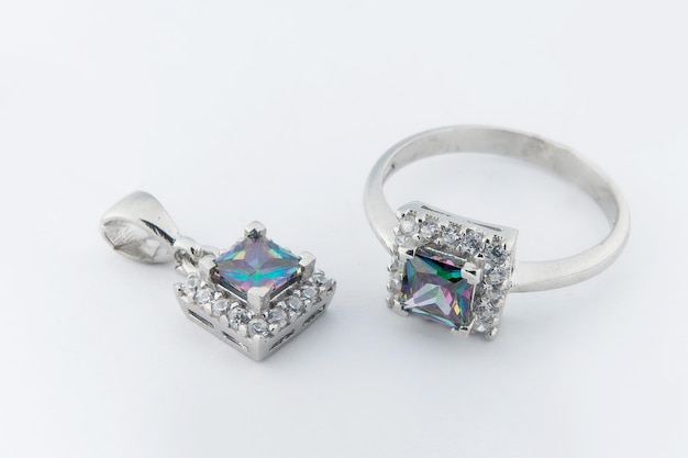 Conjunto de joias elegantes de colar de anel de ouro branco e brincos com diamantes Conjunto de joias de prata com pedras preciosas Conceito de natureza morta do produto