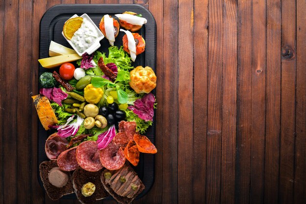 Conjunto de lanches com carne e legumes em conserva Cozinha italiana Vista superior sobre fundo de madeira