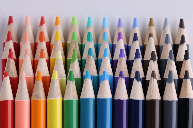 Conjunto de lápis multicoloridos deitado na mesa branca em linha