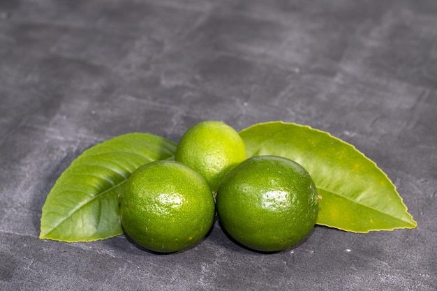 Conjunto de limones verdes frescos sobre fondo gris