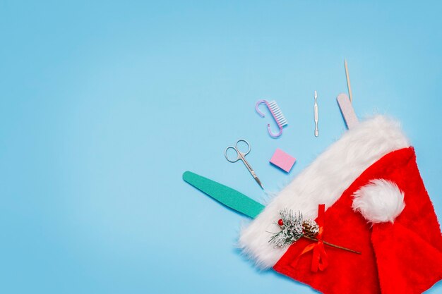 Conjunto de manicure em um chapéu de Papai Noel vermelho sobre um azul