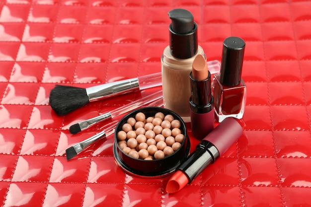 Conjunto de maquiagem com pincéis cosméticos em fundo vermelho