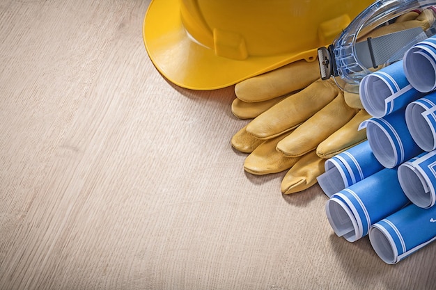 Foto conjunto de modelos de óculos de luvas de proteção de capacete de construção no conceito de construção de tábuas de madeira