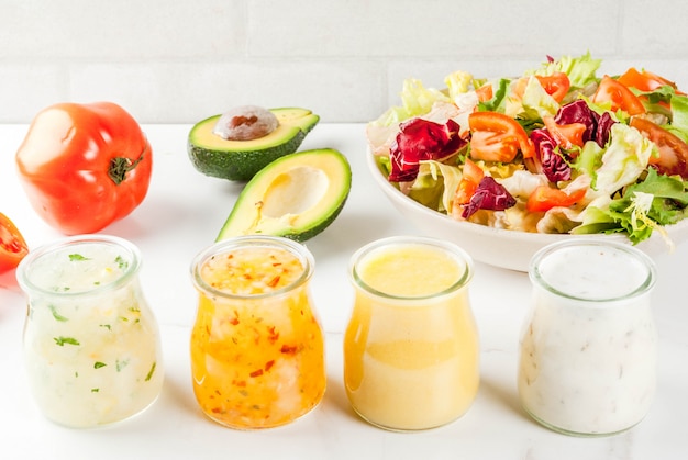 Conjunto de molhos para salada clássicos mostarda, rancho, vinagrete, limão e azeite de oliva, na mesa de mármore branca