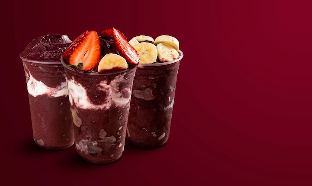 Conjunto de muitas tigelas de sorvete de açaí congeladas brasileiras com ingredientes diferentes em um fundo roxo de verão. vista superior e vista frontal para o menu.