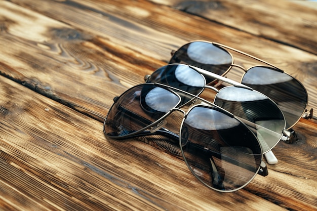 Conjunto de óculos escuros em superfície de madeira marrom