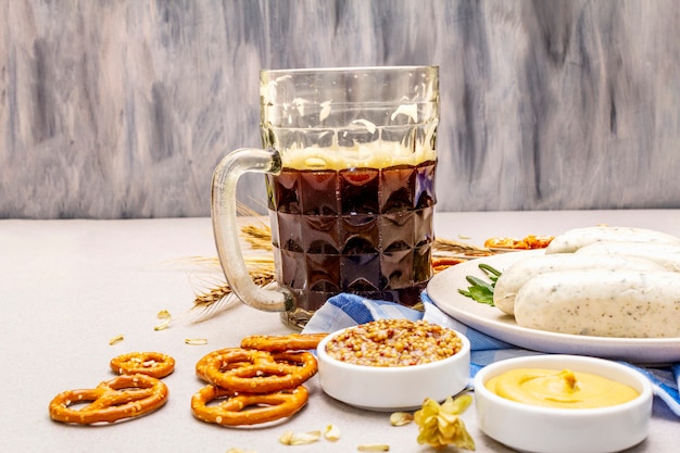 Conjunto de oktoberfest. cerveja escura, weisswurst, pretzels, mostarda, espigas de grãos, lúpulo