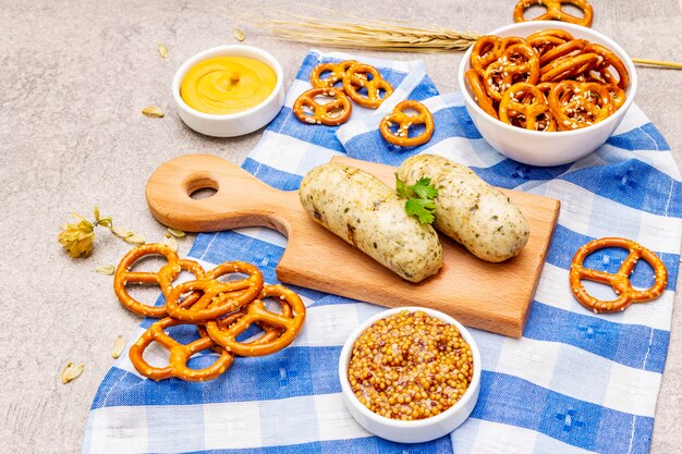 Conjunto de Oktoberfest. Weisswurst de linguiça branca, pretzels, mostarda, espigas de grãos, lúpulo