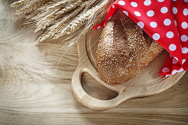 Conjunto de orelhas de pão de centeio guardanapo vermelho polkadot tábua em fundo de madeira