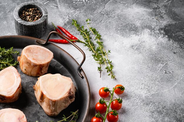 Conjunto de ossos de carne para fazer caldo, no fundo da mesa de pedra cinza, com espaço de cópia para texto