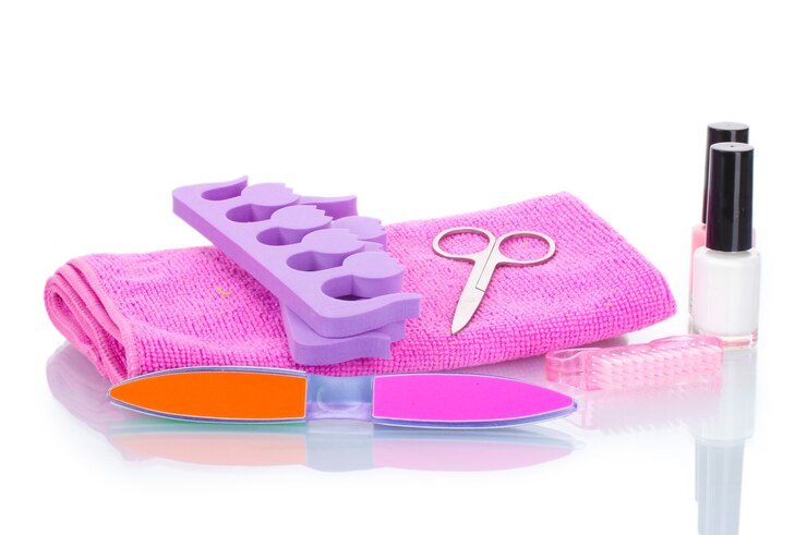 Foto conjunto de pedicura em toalha rosa isolado no branco