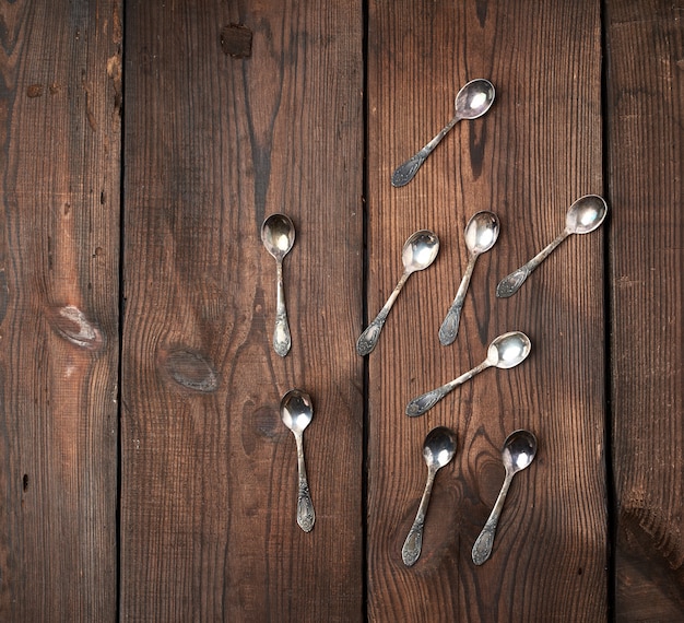 Conjunto de pequenas colheres de chá de metal em uma mesa de madeira marrom