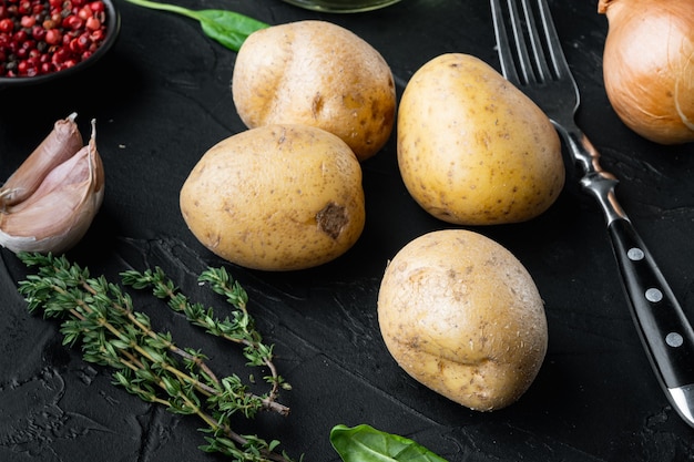 Conjunto de pilha de batatas frescas, em fundo preto