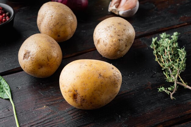 Conjunto de pilha de batatas frescas, no fundo da velha mesa de madeira escura