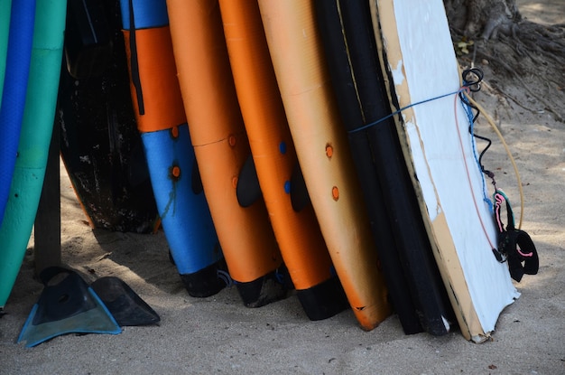 Conjunto de pranchas de surf de cores diferentes em uma pilha pelo oceano