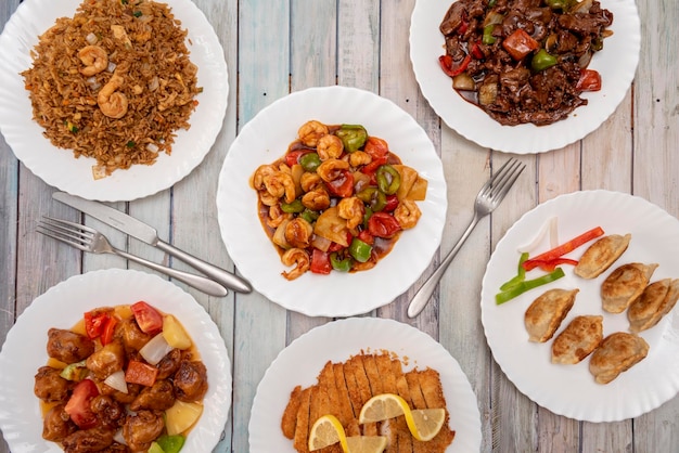 Conjunto de pratos representativos dos restaurantes chineses da Europa Frango ao limão Arroz salteado com camarão Vitela de porco agridoce com molho de ostra gyozas fritos