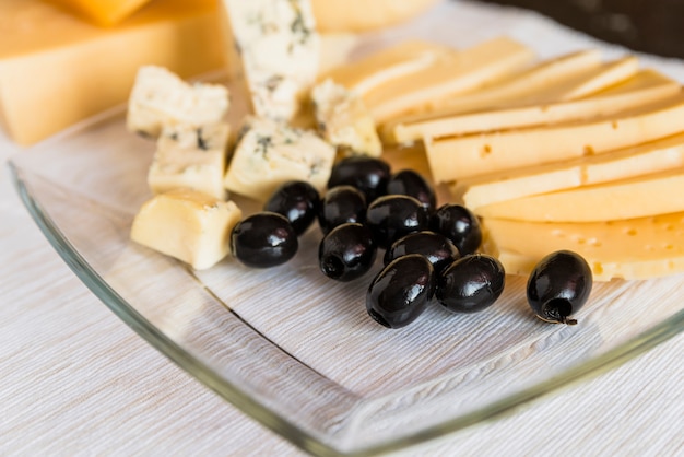 Foto conjunto de queijo fresco e azeitonas na placa