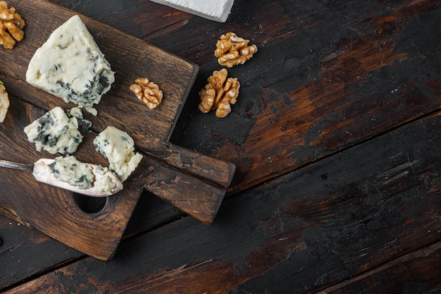 Conjunto de queijo roquefort francês, em fundo escuro de madeira, plano com espaço de cópia para o texto