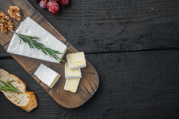 Conjunto de queijo tipo brie, em mesa de madeira preta, plano com espaço de cópia para o texto