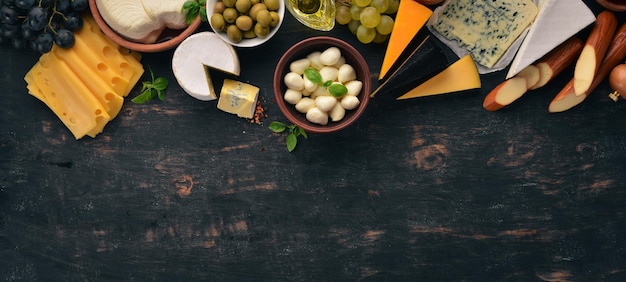 Conjunto de queijos Queijo azul Suluguni mussarela maasdam queijo brie Vista superior Em um fundo de madeira preto Espaço para cópia gratuita