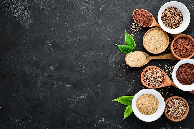 Conjunto de quinoa Quinoa vermelha, branca e marrom. Em um fundo preto. Vista do topo. Espaço de cópia grátis.