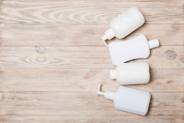 Conjunto de recipientes de cosméticos brancos na madeira