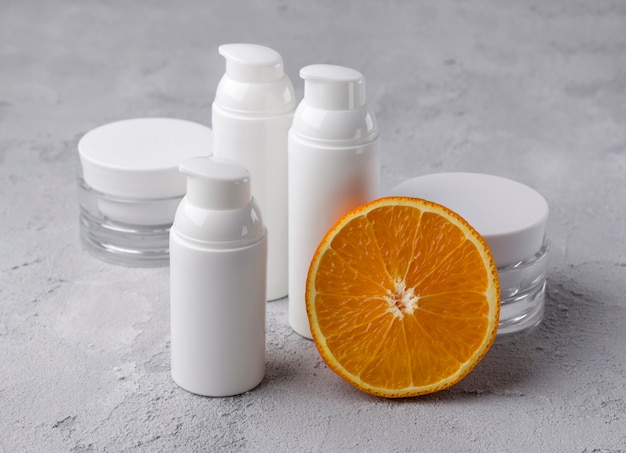 Conjunto de recipientes de garrafa cosmética com laranja.