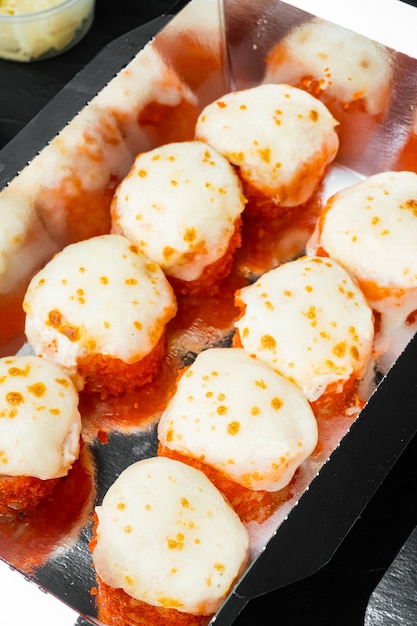 Conjunto de rolos de sushi em caixa de comida de entrega, na mesa de pedra preta