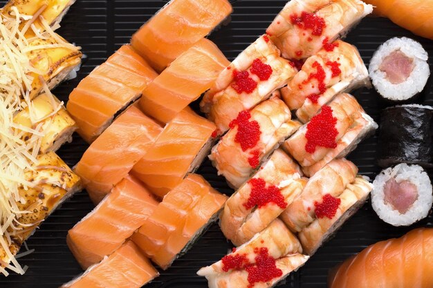 Conjunto de rolos de sushi em uma vista superior de fundo preto