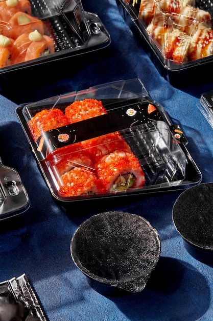 Conjunto de rolos de sushi embalado em recipientes de plástico fechados para entrega ao cliente