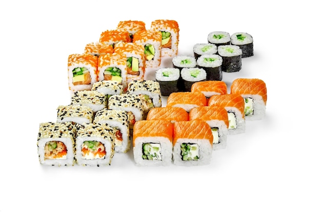 Conjunto de rolos de sushi japonês com tobiko de enguia de salmão e legumes em branco