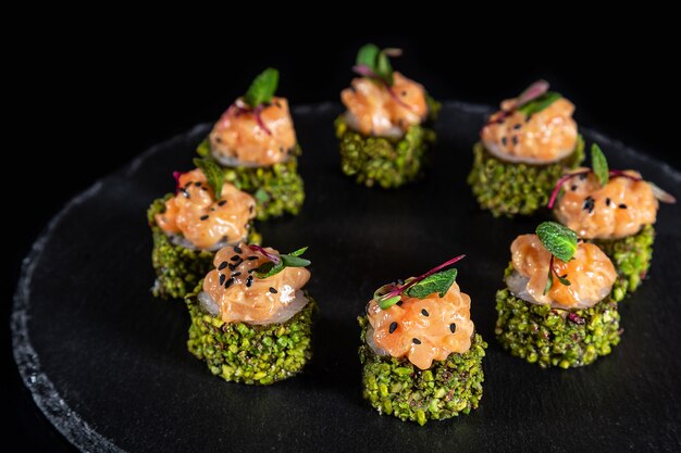 Conjunto de rolos de sushi no fundo da mesa de pedra preta