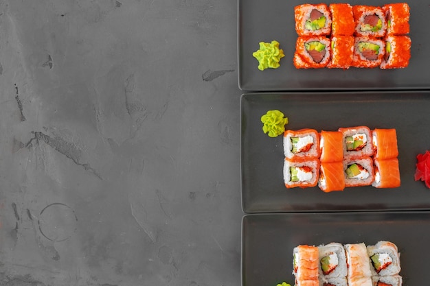 Conjunto de rolos de sushi servido em fundo cinza