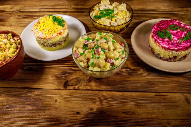 Conjunto de saladas de maionese festivas na mesa de madeira