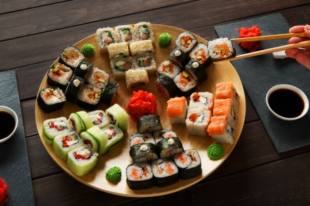 Conjunto de sushi maki e rolos em madeira rústica preta